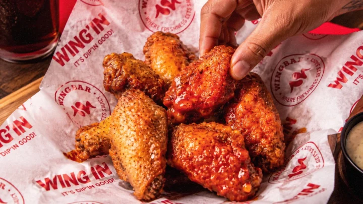 Sauced wings on WING’IN branded paper.