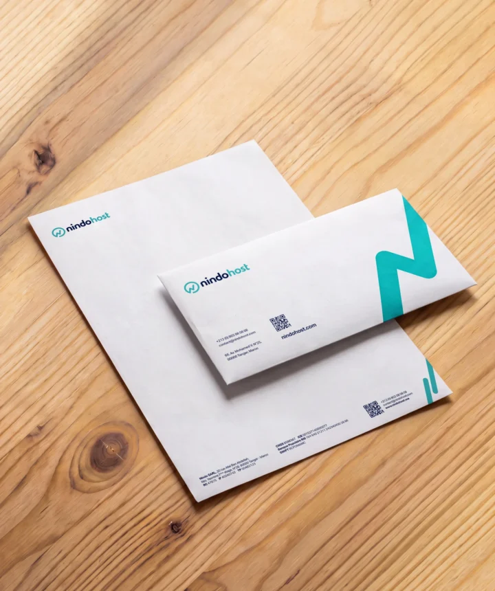 Nindohost branded envelopes and stationery on a wooden desk.